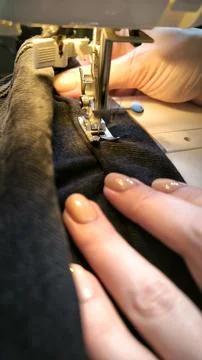Process of sewing in a sewing machine sew woman's hands manicure black text.. Foto stock