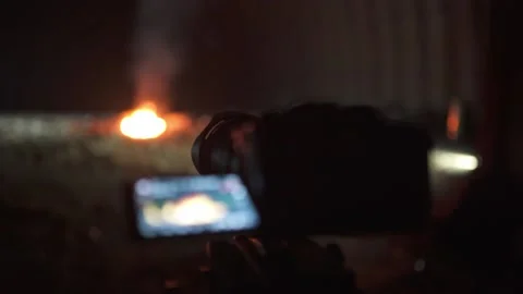 Process of shooting a big fire on professional camera with tripod in hangar Stock Footage 144673005