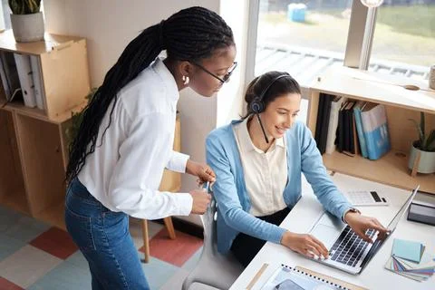 The process is simple. two businesswomen using a headset and computer while Stock Photos