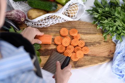 Process of slicing carrots with wavy fluted knife, quilling, vegetables in st Stock Photos