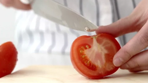 Process of slicing fresh tomato for a salad on a wooden board in slow motion Stock Footage 94122159
