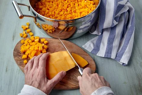 The process of slicing pumpkin on a cutting board and into a saucepan Stock Photos