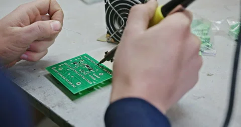 The process of soldering with a soldering iron to create a chip. A male Stock Footage 148646882