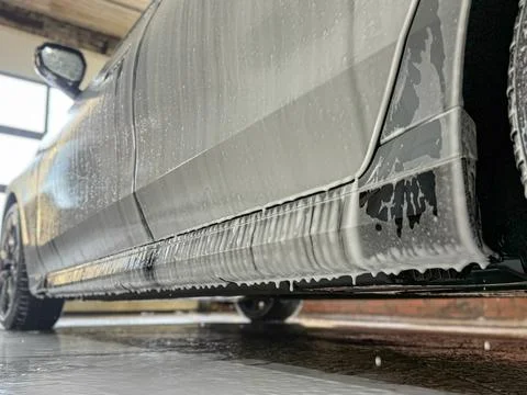 Process of spraying foam on the auto body in the station. Stock Photos