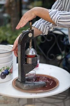 Process of squeezing pomegranate juice using manual mechanical juicer to obtain Stock-Fotos