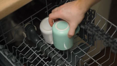 The process of stacking cups in the dishwasher, close-up. Cleaning dirty dishes Stock Footage 324698710