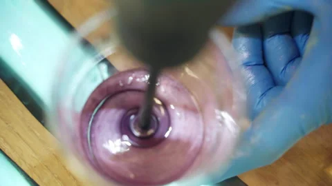 Process of stirring pink substance in plastic cup made of transparent epoxy Stock Footage 265891137