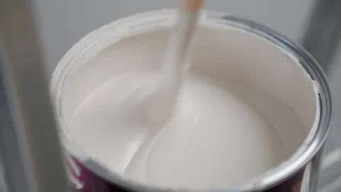 Process of stirring white paint in open can Stock Footage 337402624