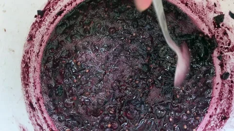 In the process of stirring the wine in a bucket with a spoon at home during the Vídeos de archivo 246049009