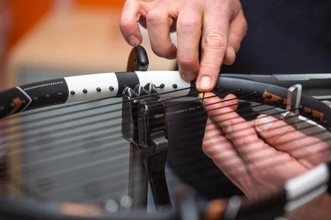 Process of stringing a tennis racket in a tennis shop, sport and leisure concept Stock Photos