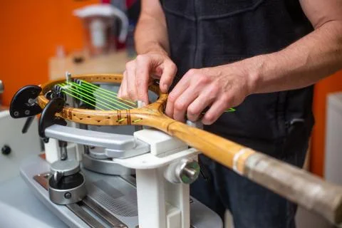 Process of stringing a tennis racket in a tennis shop, sport and leisure concept 库存照片