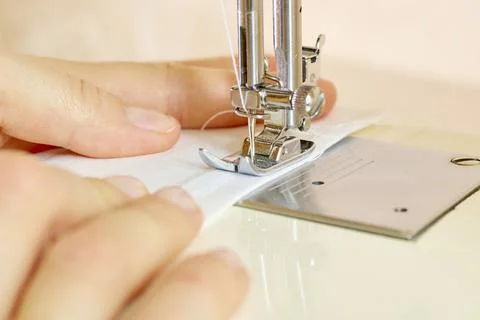 The process of tailoring clothes on a sewing machine. A woman sews at a sewing Stock Photos