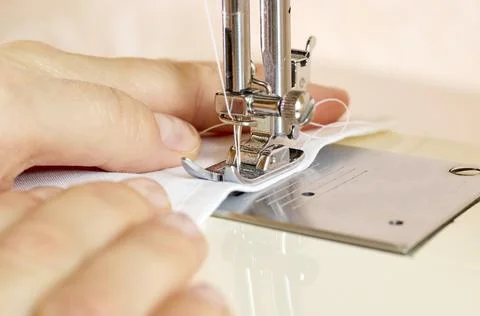 The process of tailoring clothes on a sewing machine. A woman sews at a sewing Stock Photos