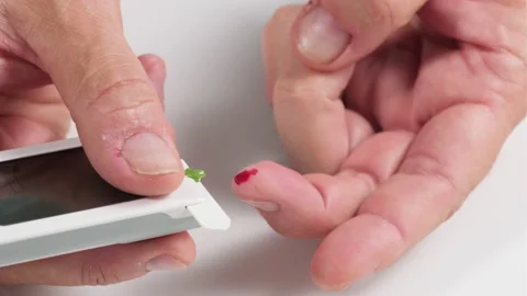 Process of taking blood from a finger to a test strip  Stock Footage 135774288