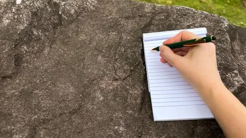 The process of taking notes in a notebook with a green ballpoint pen Stock Photos