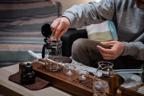 The process of tea ceremony at home. The tea master puts pieces of raw aged Stock-Fotos
