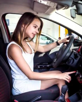Process of testing vehicle. Beautiful blonde girl sitting in the new car with Stock Photos