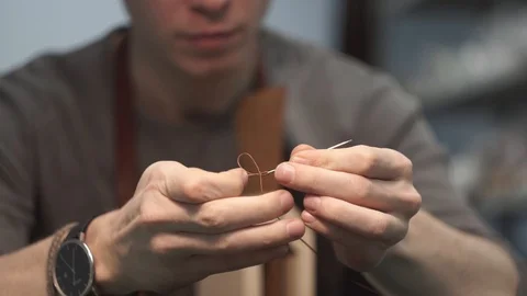 The process of threading a needle. The tanner has a thread before starting to Stock Footage 104927695