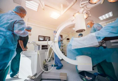 Process of trauma surgery operation. Group of surgeons in operating room Stock Photos