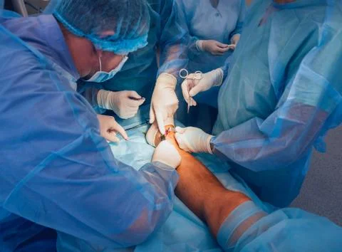 Process of trauma surgery operation. Group of surgeons in operating room Stock Photos