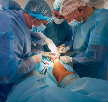 Process of trauma surgery operation. Group of surgeons in operating room Stock Photos