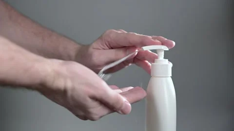The process of treating hands with a sanitizer. Stock Footage 153419480