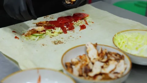 The process of twisting and wrapping meat and vegetables in pita bread. Stock Footage 309818514