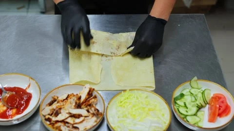 The process of twisting and wrapping meat and vegetables in pita bread. Stock Footage 309818645