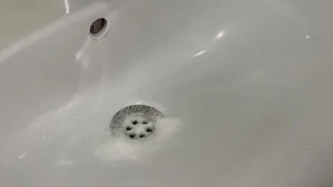 The process of unclogging a clogged sink. Person pouring chemicals to clear c Stock Footage 249594992