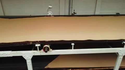 Process of unwinding roll of kraft paper in workshop for production of Stock Footage 282669218