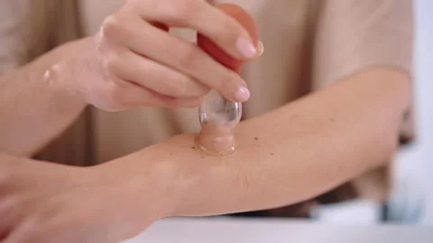 Process of vacuum massage with silicone cup and emollient oil, woman smoothing Stockbeeldmateriaal 232220669