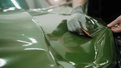 Process of vinyl wrapping a car in dark green color using plastic cards Stock-Footage 171959925