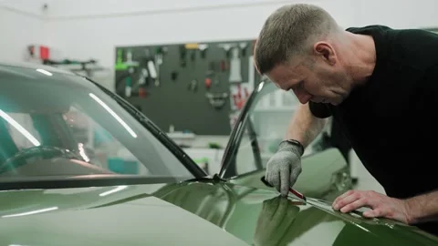 Process of vinyl wrapping a car in khaki green color, cutting the wrap Video stock 171960964
