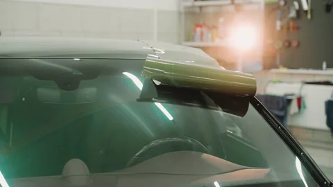 Process of vinyl wrapping a car in a work studio, laying vinyl film on car roof Vídeo Stock 171961776