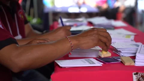 The process of the voting organizer group stamping each paper card for Video stock 265234960