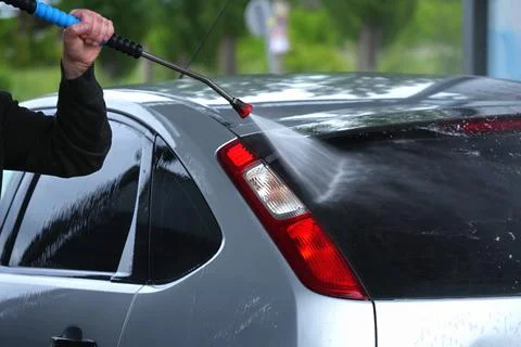 The process of washing a car using a high-pressure device. Stock Photos