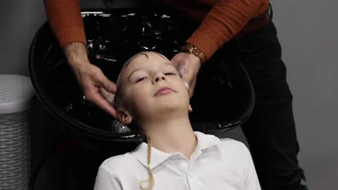 The process of washing head a blond boy in a chair in a barbershop salon, a Stock-Footage 146592350