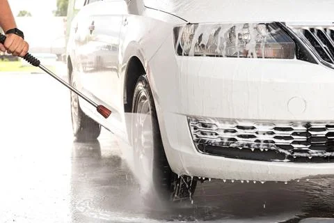 The process of washing a white car at a self-service car wash Stock Photos