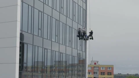 The process of washing windows in high-rise buildings. Two workers wash windo Stock-Footage 211111932