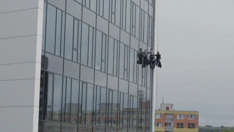 The process of washing windows in high-rise buildings. Two workers wash windo Stock Footage 211111950
