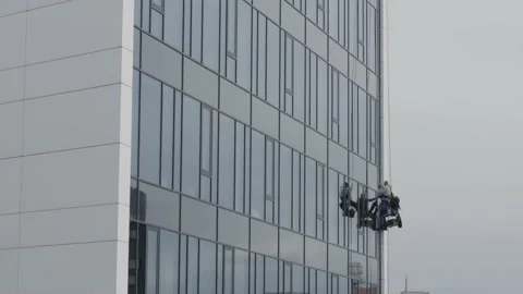 The process of washing windows in high-rise buildings. Two workers wash windo Stock Footage 211111967