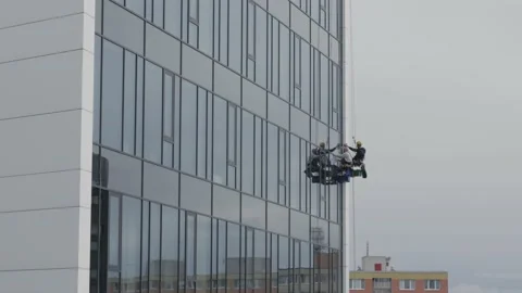 The process of washing windows in high-rise buildings. Two workers wash windo Stock Footage 211111968