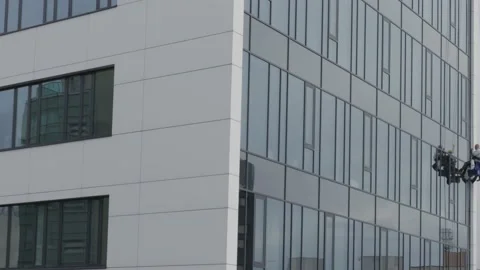 The process of washing windows in high-rise buildings. Two workers wash windo Video stock 211111988