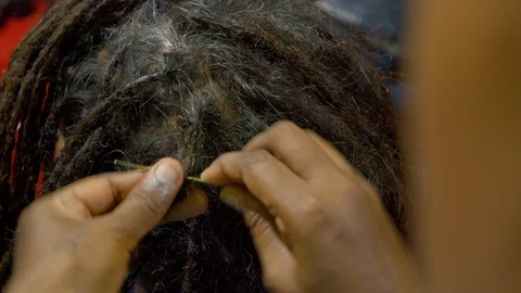 The process of weaving dreadlocks in an Indian salon. Stock Footage 129130144