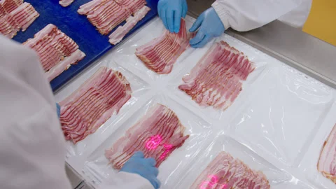Process of weighing sliced bacon before packaging. Laser displays weight of each Stock Footage 205488746