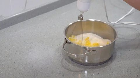 The process of whipping egg yolks with a mixer. Stock Footage 128835656