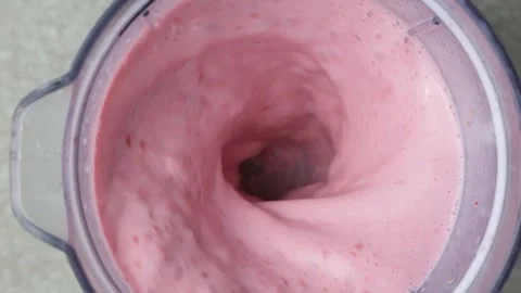 The process of whipping strawberry milkshake in a blender slow motion Stock Footage 311698275
