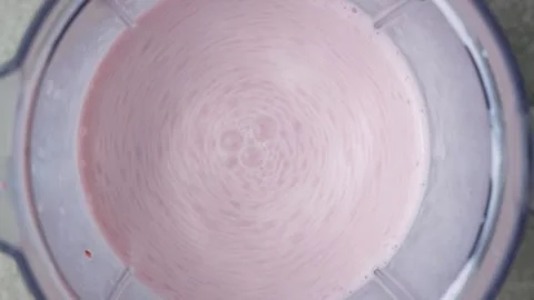 The process of whipping strawberry milkshake in a blender. Stock Footage 312605392