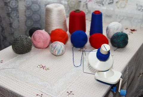 Process of winding coiler a blue yarn into a reel on background of of multi.. Foto stock