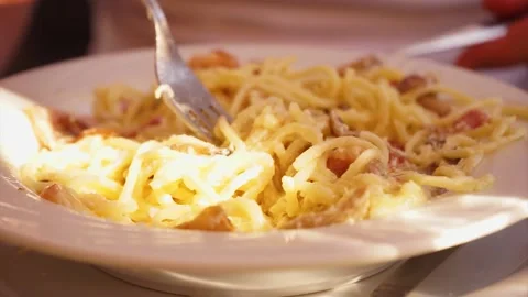 The process of winding pasta Carbonara on a fork Stock Footage 143473372
